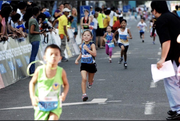 Kira Ellis running to the finish line in a kiddy triathlon race