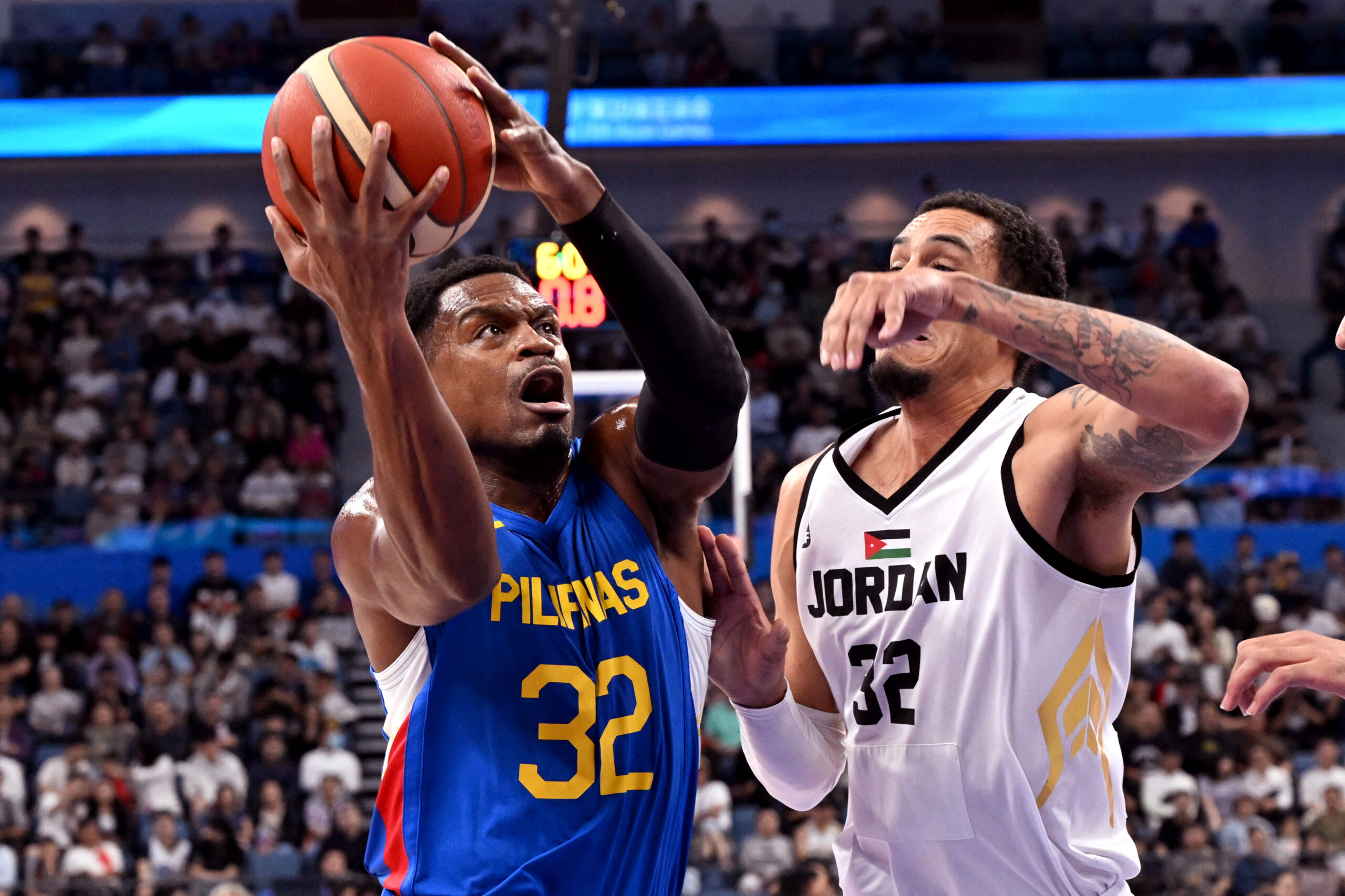 Philippines' player Justin Brownlee (L) is challenged by Jordan's John Bohannon during the men's gold medal basketball game between Jordan and Philippines at the 2022 Asian Games in Hangzhou in China's eastern Zhejiang province on October 6, 2023. (Photo by William WEST / AFP)