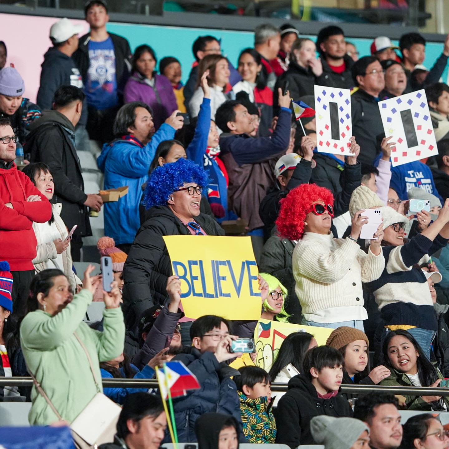 Filipino sports fans cheering on the national football team in the Women's World Cup.